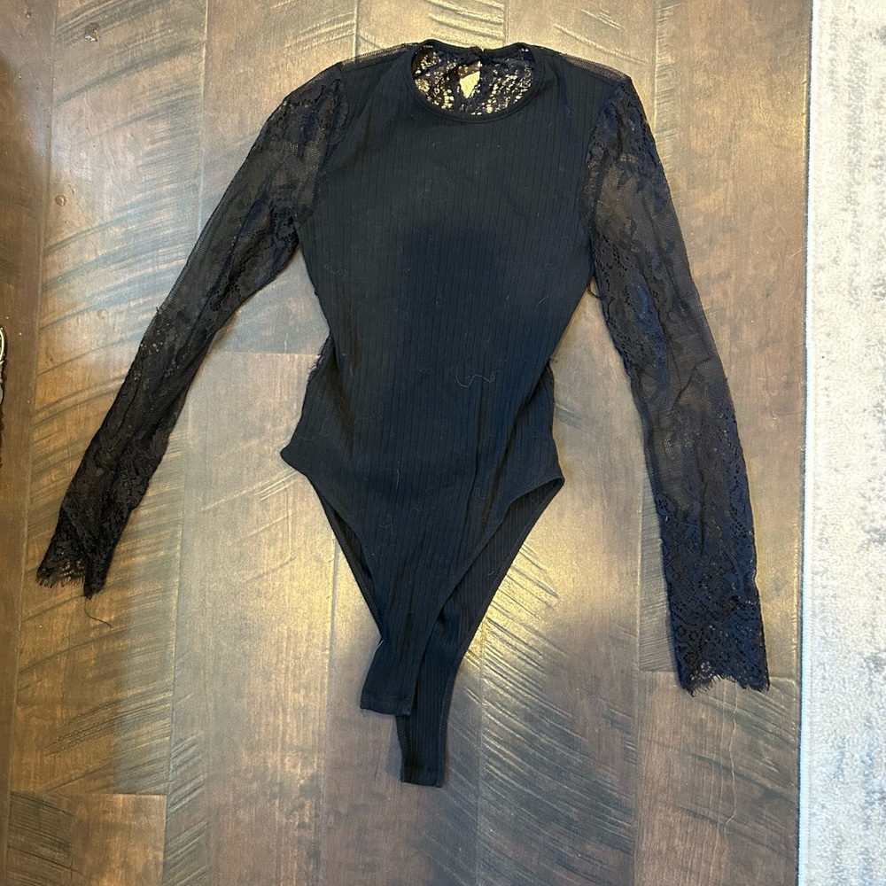 Black body suit with lace sleeves and open back